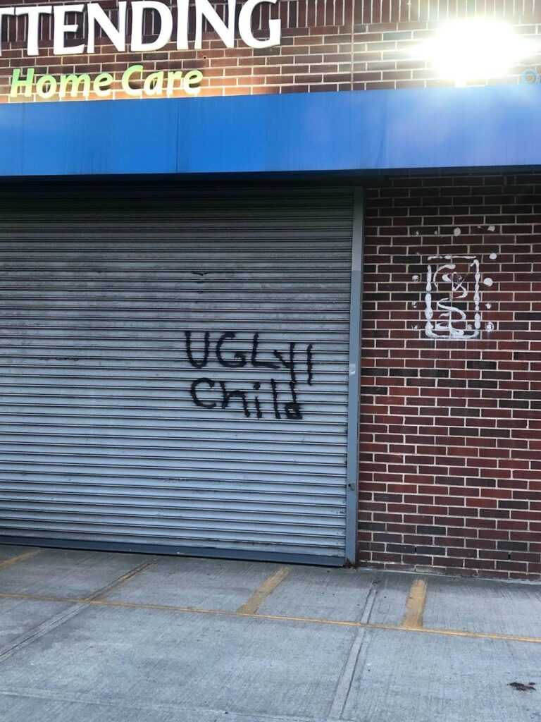 "Ugly Child" tagged in black spray paint on a metal garage door in Prospect Lefferts Gardens